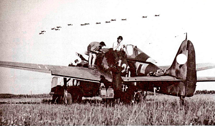 Группа пикирующих бомбардировщиков Ju-87 в воздухе ждет когда взлетят их истребители сопровождения.