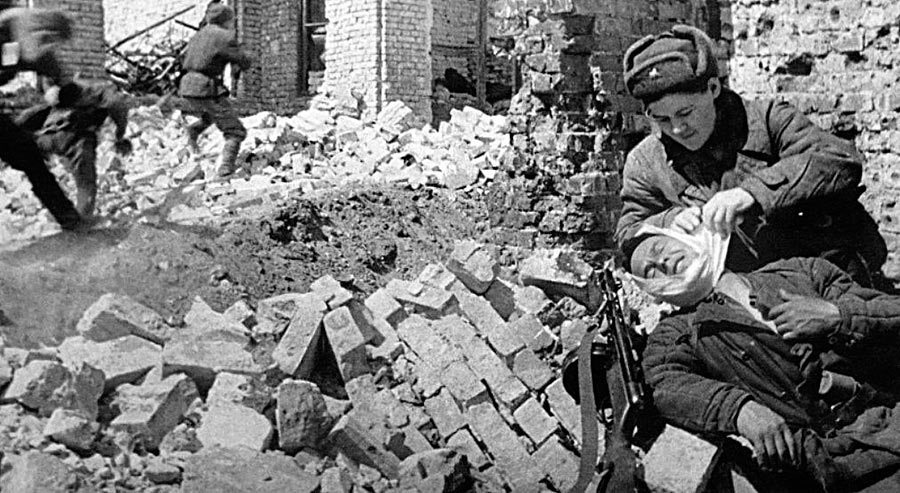Санинструктор оказывает помощь раненному солдату, бои в Сталинграде.