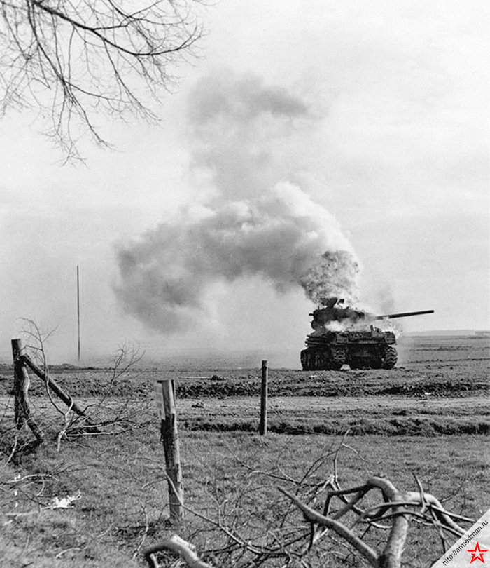 Горящий американский танк «Шерман» 3-й танковой дивизии США, подбитый немецкой артиллерией в Бергерхаузене, Керпен, Германия. Модификация танка M4A1(76)W, в отличие от «Шерманов» передававшихся СССР по ленд-лизу M4A2, имевшая не дизель, а бензиновый двигатель. Англичане даже обзывали танки этого типа «Ронсон», по названию популярной бензиновой зажигалки.